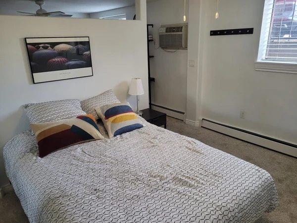 Cleaned bedroom with a made bed and framed art