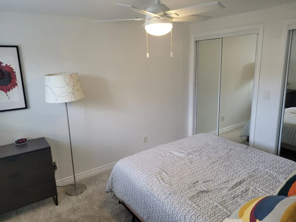 Cleaned bedroom with a floor lamp and closet