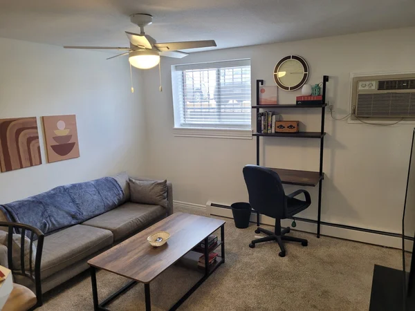Cleaned living room with a sofa, coffee table and desk
